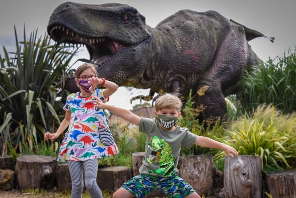 children wearing dinosaur masks outside roarr! dinosaur adventure park