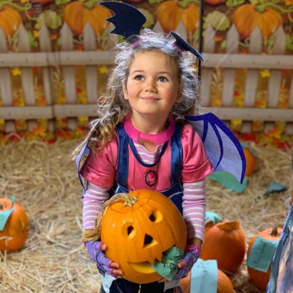 Child and pumpkin at Wroxham Barns Halloween event