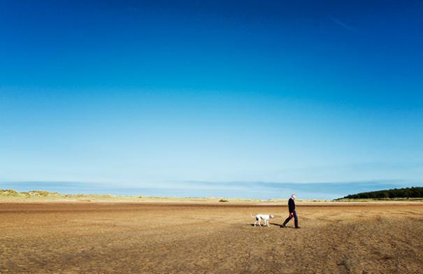 Man walking his dog on Holkham Beach
